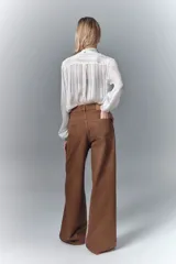 Pantalón jean de corte oxford tiro alto, color habano, confeccionado en denim rígido.