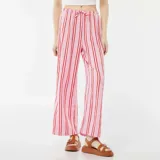 Pantalón ancho de punto gofrado color rosa con rayas verticales rojas y cintura con cordón ajustable.