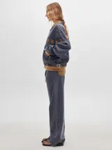 Pantalón de denim color marrón claro, de tiro alto, corte amplio y pinzas en la cintura.