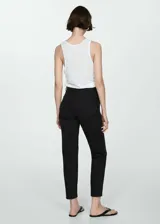 Pantalón de jeans negro de corte mom-fit, tiro alto, cinco bolsillos, trabillas y cierre con cremallera y botón.
