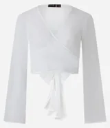 Blusa cropped de chiffon color blanco, con escote en V cruzado, mangas largas acampanadas y lazo en la espalda.
