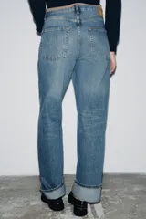Jeans de mujer tiro medio, corte ancho (baggy) y pierna recta, con efecto lavado azul claro. Presenta cinco bolsillos y bajo acabado con vuelta ancha.