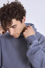 Buzo canguro con capucha color lila, de friza gastada.