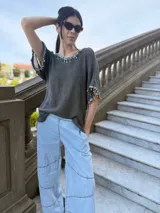 Remera tejida color marrón con hilado 100% algodón y cintas de piedras aplicadas en cuello y mangas.