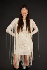 Minivestido color champagne con lentejuelas y flecos largos.