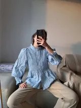 Camisa celeste y blanca a cuadros con cuello mao, mangas largas abullonadas con puños elásticos y peplum.
