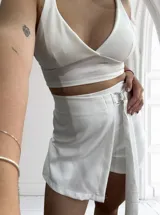 Short de vestir color blanco con corte de pollera cruzada y lazo lateral con hebilla metálica.