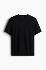 Remera negra de punto fino, con cuello redondo y mangas cortas. Corte ajustado.