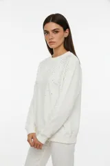 Buzo de corte amplio color marfil con cuello redondo y mangas largas.