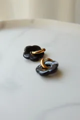 Aros de acero quirúrgico hipoalergénico con diseño de flores en tonos marrón y dorado.