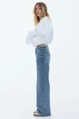 Pantalón de jean azul de tiro alto, corte wide leg y cinco bolsillos.