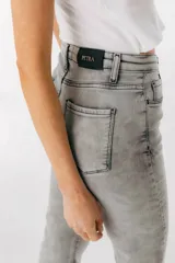 Pantalón de jean azul de corte acampanado con aberturas en el ruedo.