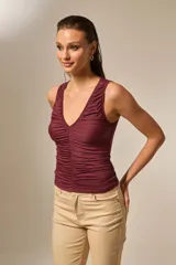 Top negro sin mangas de poliéster, con escote en V profundo y frunces en la parte delantera.