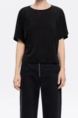 Camiseta negra fluida de corte boxy, con escote a la caja, manga corta y pliegues en el hombro.