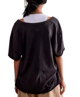 Remera negra de algodón, con escote en V profundo, mangas cortas y hombros caídos.