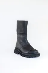 Bota de caña media color negro, de cuero, con suela track y puntera redondeada.