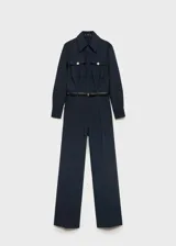 Mono largo negro de corte slim fit, con cuello camisero, cierre frontal con botones, cinturón con hebilla dorada, dos bolsillos de parche con solapa en el pecho, puños abotonados y trabillas.