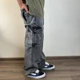 Pantalón jean cargo gris con efecto lavado y corte mega oversize.