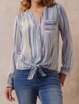 Blusa de gasa estampada a rayas verticales en tonos celeste, lila, naranja y marrón. Tiene cuello a la base con escote en V y botones. Delantera con bolsillo aplicado. Largo de manga regulable con presilla y botón. Terminación anudada opcional.