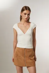 Top blanco de manga corta, ajustado al cuerpo y con escote profundo en V.