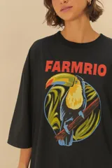 Mono corto negro con estampado de un tucán dentro de un círculo con hojas.