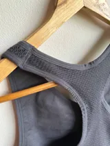 Top deportivo gris oscuro con espalda estilo racerback y banda elástica acanalada en el bajo busto.