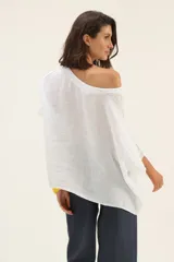 Blusa blanca de lino con mangas murciélago y escote redondo.