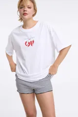 Remera color beige con estampado de sardinas, limones y aceitunas.