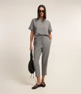 Blusa de crepé con estampado geométrico en blanco y negro, escote redondo y mangas cortas con detalle de doblez.