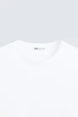 Camiseta slim fit de manga corta y cuello redondo, confeccionada en tejido de algodón con elasticidad.