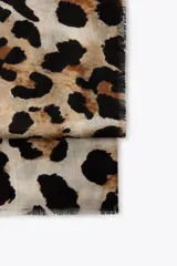 Pañuelo rectangular con estampado de leopardo y terminaciones deshilachadas.