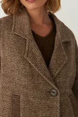 Saco amplio color crema, de tela patchwork con manga ranglan y ruedo irregular.