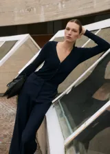 Mono largo azul marino de tejido de punto de canalé con cuello de pico, cierre de botones en la parte delantera, dos bolsillos laterales, diseño recto, manga larga y trabillas.