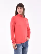 Polera de cuello alto color coral, de mangas largas y corte ajustado.