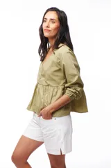 Blusa color verde oliva con escote en V, mangas largas abullonadas con puños elásticos y detalle de calado en hombros y cintura.