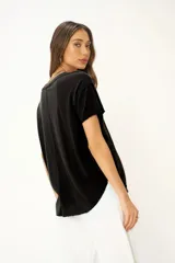 Camiseta blanca de cuello en V, con hombros caídos, dobladillo curvo y ajuste holgado.