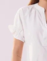 Blusa blanca de gasa marca Floral & Ivy, con cuello a la base y escote en V. Mangas cortas con elástico fruncido.