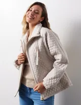 Campera beige capitoneada marca Weatherproof, con cierre central, bolsillos delanteros y forro interno.