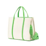 Bolso tipo tote de tela color crudo con detalles en cuero sintético verde. Tiene doble asa corta, correa larga regulable y extraíble, bolsillo frontal con cierre, cierre principal, bolsillo interno con cierre y dos bolsillos internos abiertos.