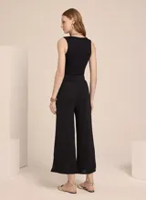 Pantalón recto de tejido de punto negro, con cinturilla aplicada y aberturas laterales.