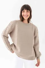 Sweater color visón de punto con cuello redondo y mangas largas con diseño trenzado.