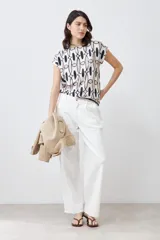 Blusa de manga corta con estampado geométrico en tonos beige, blanco y negro.