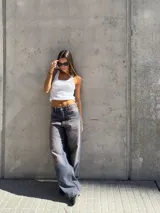 Pantalón jean azul con efecto lavado, corte wide leg y tiro bajo.