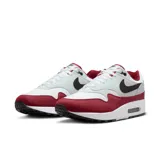 Championes Nike Air Max 1 de hombre, color blanco, gris y rojo, con logo negro en el lateral.