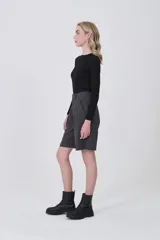 Bermuda de poliéster color gris oscuro, con pinzas frontales y corte holgado. Presenta un calce a media pierna.