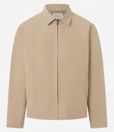 Campera masculina color marrón confeccionada en sarga, con cuello inglés, cierre de cremallera frontal, manga larga y bolsillos con detalles.