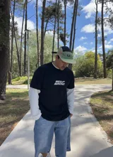 Remera negra de algodón de corte oversize con estampado en la espalda con un logo de reciclaje y la frase "XTREME WEAR BREAKING RULES".