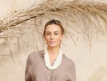 Collar de mostacillas blancas de múltiples hilos, con caravanas colgantes a juego.