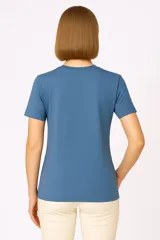 Remera blanca de algodón con estampado frontal que dice 'URUGUAY noma!' en letras azules y negras.