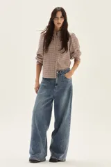 Jean de mujer, color azul medio lavado, tiro alto y corte ancho (wide leg).